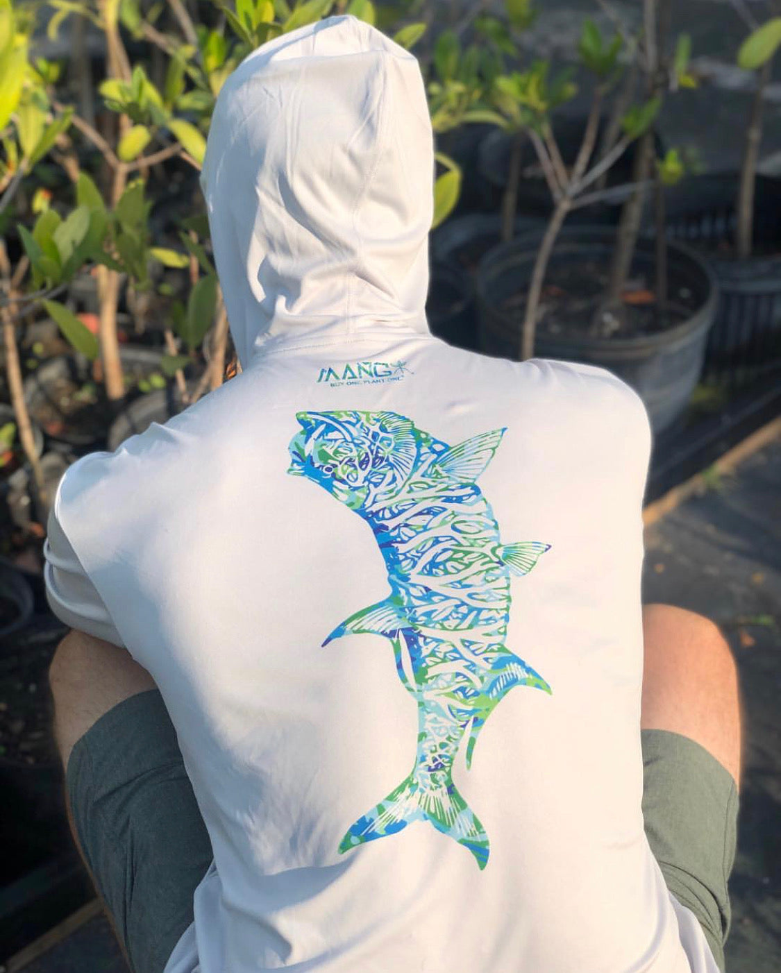 Back view of a man planting a mangrove seedling with a longsleeve performance hoodie