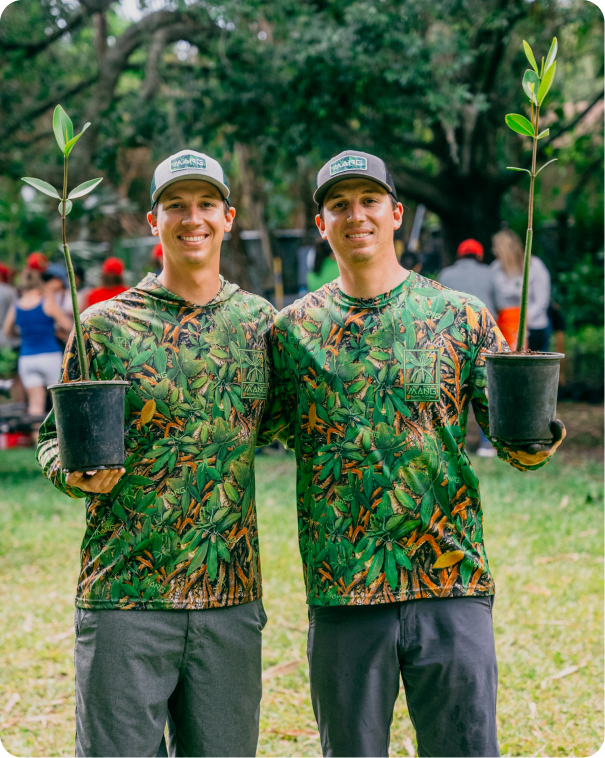 MANG founders Kyle and Keith Rossin posing for a photo with potted mangrove plants