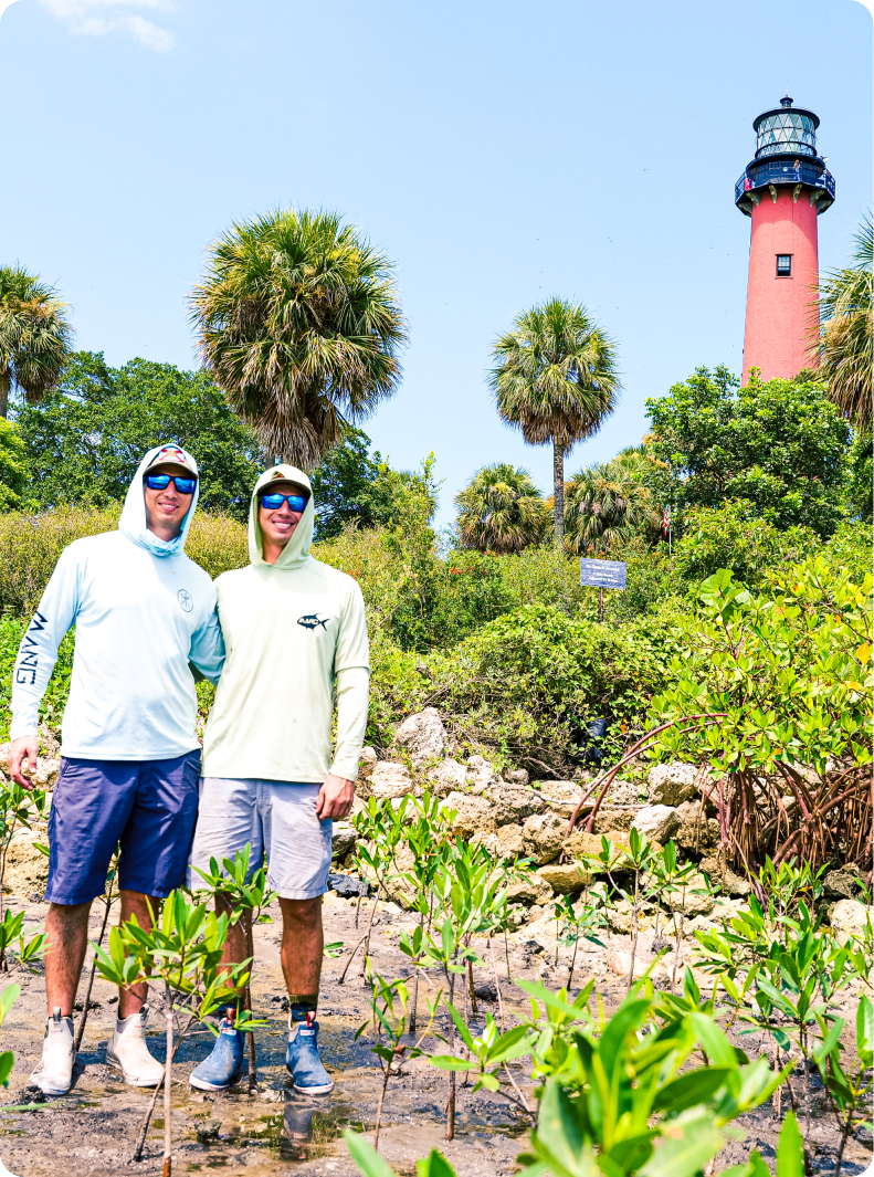 Keith and Kyle Rossin of MANG Gear posing for a photo next to Jupiter Lighthouse