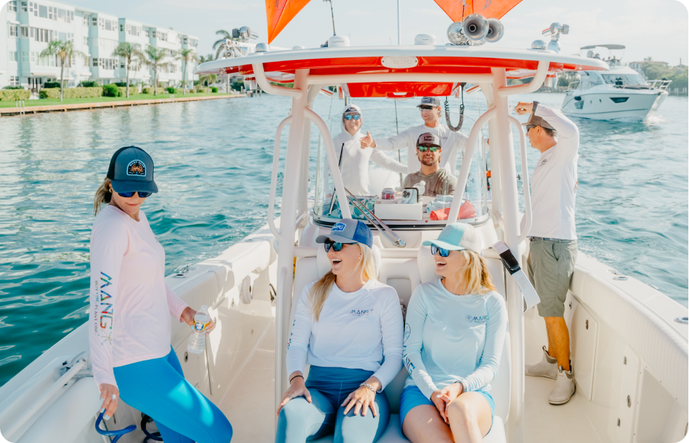 Rossin Brothers posing for a photo with people on a boat wearing MANG apparel