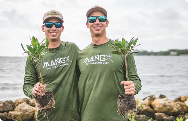 Keith and Kyle Rossin posing for a photo together holding mangrove seedlings on Florida Coasts